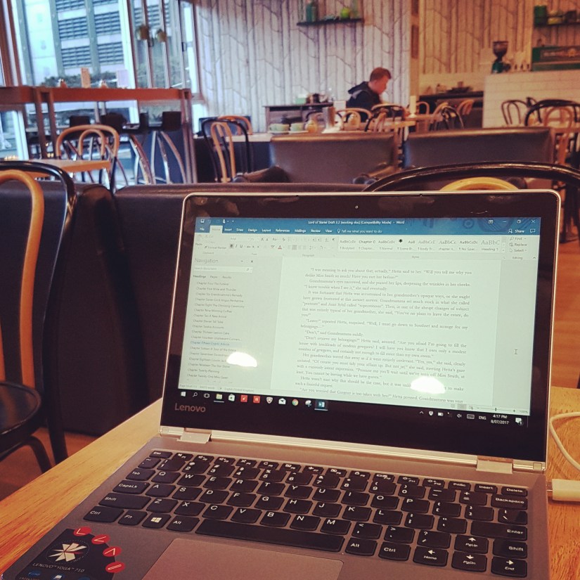Small laptop on a cafe table with a view of The Annexe